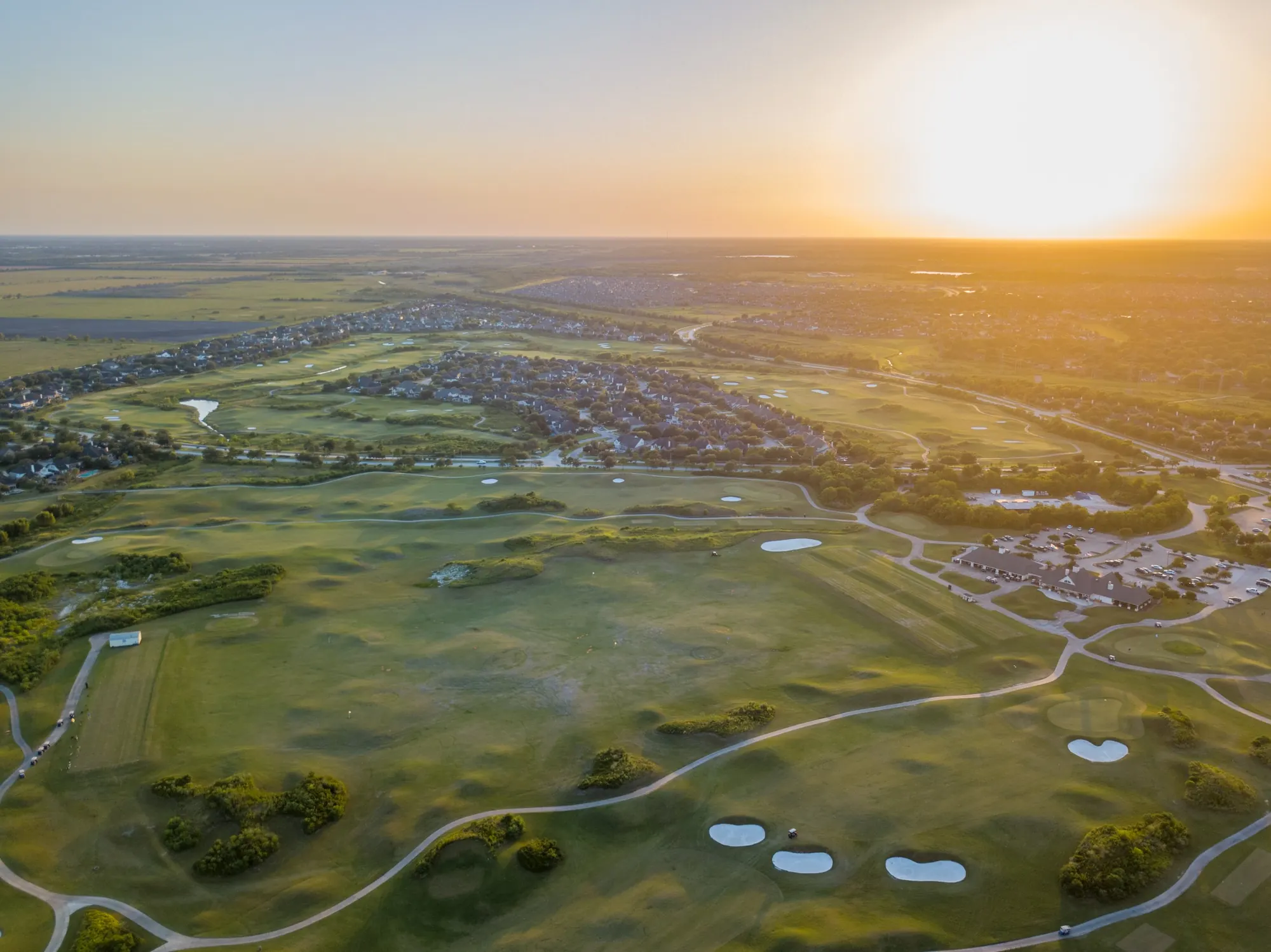 Aerial view of a golf course and neighborhoods at sunset in League City, Texas