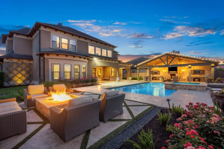 Backyard pool, outdoor kitchen and fire pit at twilight in a luxury home